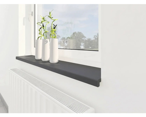 Rebord de fenêtre intérieur moderne en gris anthracite, monté au-dessus d'un radiateur blanc sous une fenêtre avec des plantes décoratives.