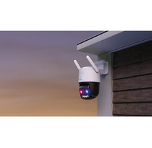 Caméra de surveillance extérieure montée sur un mur sous un avant-toit, avec antennes et fonction de vision nocturne active.