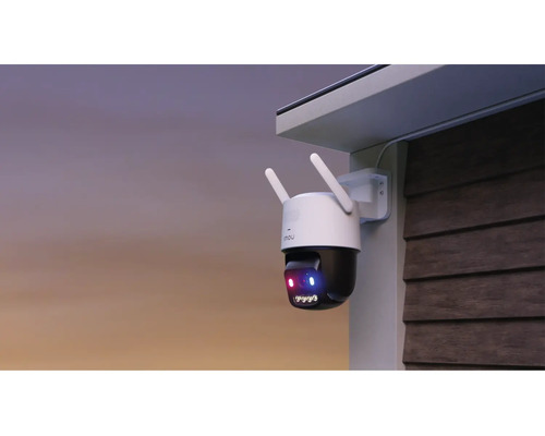 Caméra de surveillance extérieure montée sur un mur sous un avant-toit, avec antennes et fonction de vision nocturne active.