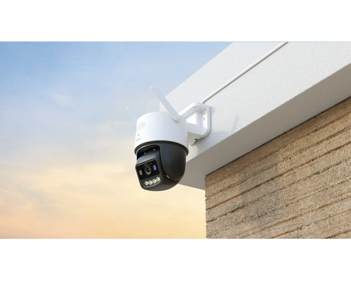 Caméra de surveillance extérieure sans fil montée sur le mur d'un bâtiment sous un avant-toit.
