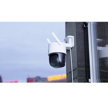 Caméra de surveillance extérieure avec deux antennes montée sur un mur extérieur.