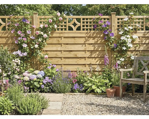 Garten-Sichtschutzzaun aus Holz mit Rankgitter, bewachsen mit Kletterrosen und Clematis, davor ein Beet mit Hortensien, Lavendel und ein Holzstuhl.