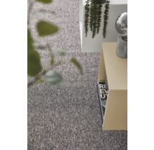 Strukturierter Teppichboden in einem modern eingerichteten Wohnraum mit Beistelltisch und Pflanze.