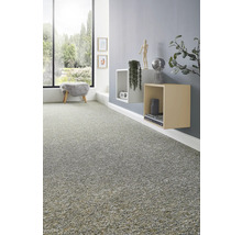 Texturierter Teppichboden in einem modern eingerichteten Wohnzimmer mit Wandregalen, Dekoration und einem großen Fenster mit Blick ins Grüne.