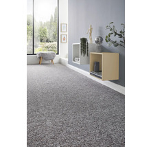 Moquette grise texturée dans une pièce moderne et lumineuse avec une grande fenêtre et des étagères murales cubiques.