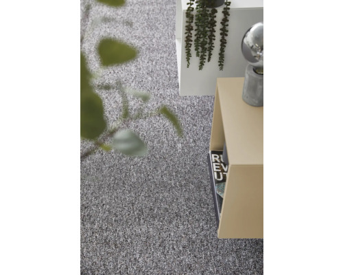 Moquette grise structurée dans une pièce lumineuse et moderne avec une table d appoint et une plante.