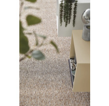 Moquette structurée beige et brune dans une pièce lumineuse et moderne avec une table d'appoint et des plantes.