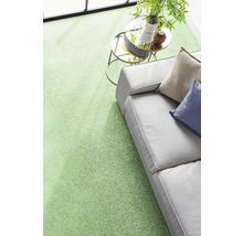 Moquette verte moderne dans un salon lumineux avec canapé gris et petite table.