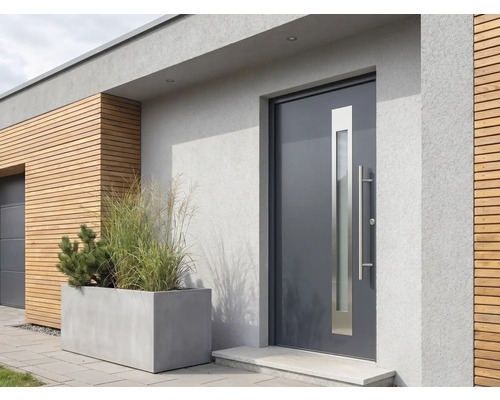 Moderne dunkelgraue Haustür mit vertikalem Glasausschnitt und langem Edelstahlgriff in einer hellgrauen Fassade neben einer Holzverkleidung.