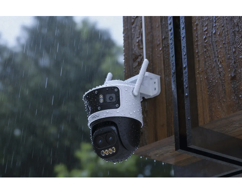 Caméra de surveillance résistante aux intempéries avec deux objectifs, montée sur un mur en bois sous la pluie.
