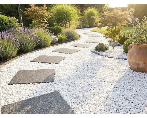 Geschwungener Gartenweg mit grauen Trittplatten in weißem Zierkies, umgeben von Lavendel, Gräsern und einem Terrakottatopf.