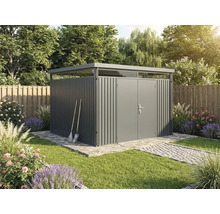 Abri de jardin moderne en métal gris avec toit plat et bandeau lumineux dans un jardin clair et soigné avec chemin en pierre et fleurs.