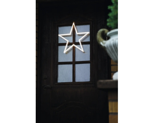 Leuchtender LED Stern in Neon Optik als Fensterdekoration an einer dunklen Holztür.