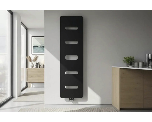 Radiateur design vertical moderne noir avec découpes horizontales sur un mur blanc dans une pièce lumineuse et minimaliste.