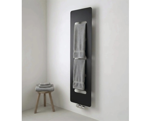 Radiateur panneau noir moderne avec porte-serviettes intégré dans une salle de bain lumineuse avec tabouret en bois et serviettes.