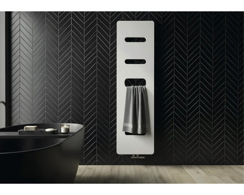 Radiateur panneau blanc moderne sur un mur carrelé noir avec motif à chevrons dans une salle de bains avec baignoire sombre.