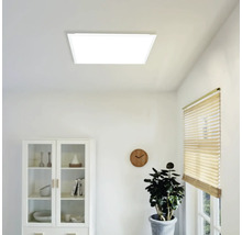 Panneau LED carré au plafond dans une pièce lumineuse au mobilier moderne avec vitrine, horloge murale et plante.