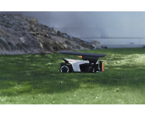 Moderne Schutzgarage für einen Mähroboter auf einer Rasenfläche bei Regen, funktionales Design zum Wetterschutz.