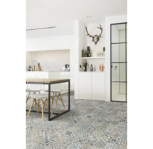 Cuisine moderne lumineuse avec carrelage de sol motif patchwork, table en bois avec cadre en métal noir et chaises en fil de fer blanc.