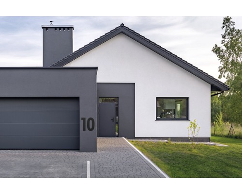 Ansicht eines modernen Einfamilienhauses mit Garage und gepflasterter Einfahrt.