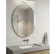 Salle de bains moderne avec un miroir mural ovale, un plan de toilette en béton avec vasque intégrée et une robinetterie murale.