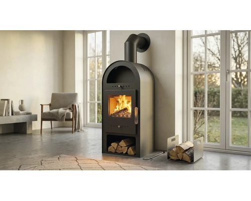 Poêle à bois noir avec partie supérieure arrondie, rangement pour bûches intégré et feu brûlant dans un salon moderne et lumineux.