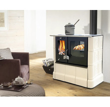 Cuisinière à bois avec carrelage, four intégré et feu allumé dans un salon lumineux.