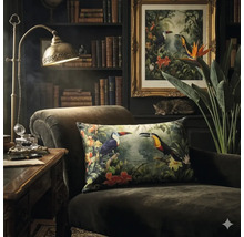 Fauteuil sombre avec coussin décoratif à motif toucan dans une pièce classique avec bibliothèque et lampe de bureau en laiton.