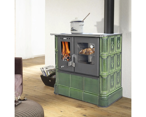 Cuisinière à bois en céramique verte avec fenêtres pour feu et four dans une pièce lumineuse avec parquet.