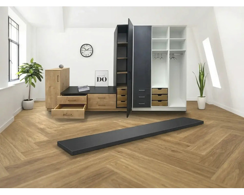Système de dressing modulable en aspect bois et noir avec tiroirs et étagères dans une pièce lumineuse avec sol en chevrons.
