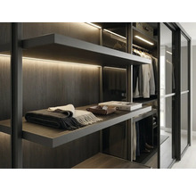 Dressing moderne avec étagères en bois foncé, éclairage LED intégré et portes coulissantes en verre.