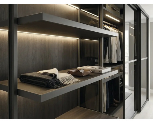 Dressing moderne avec étagères en bois foncé, éclairage LED intégré et portes coulissantes en verre.