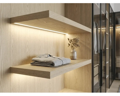 Étagère murale en bois clair avec éclairage LED intégré dans un dressing, design moderne.