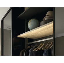 Vue intérieure d une armoire avec étagère en bois éclairée, tringle à vêtements et cintres en bois.
