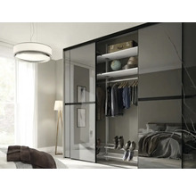 Armoire à portes coulissantes moderne avec panneaux en verre dans une chambre, intérieur avec étagères, tringle et étagère à chaussures.