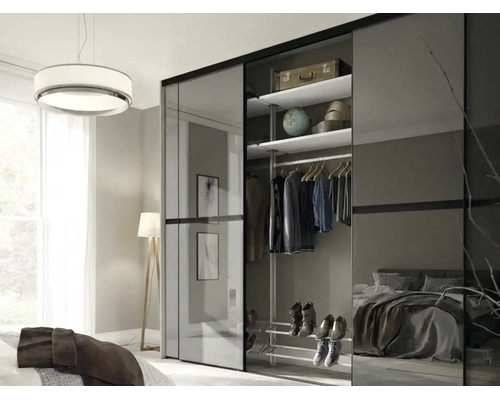 Armoire à portes coulissantes moderne avec panneaux en verre dans une chambre, intérieur avec étagères, tringle et étagère à chaussures.