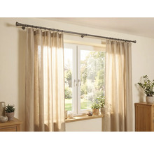 Scène lumineuse avec une tringle à rideaux en métal foncé au-dessus d'une fenêtre, rideaux beiges semi-transparents et plantes d'intérieur.