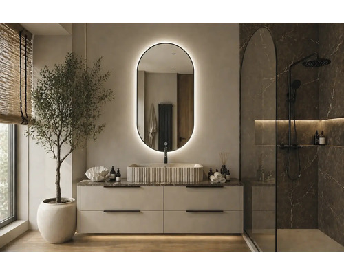 Salle de bain moderne avec miroir LED ovale, vasque à poser striée, meuble sous-vasque clair et douche à l'italienne aspect marbre.