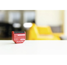Actionneur de commutation encastré Shelly Gen3 rouge pour l automatisation domestique sur une surface blanche.