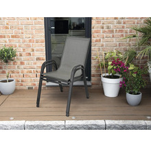 Chaise de jardin empilable avec cadre en aluminium et revêtement textile sur une terrasse en bois avec des plantes devant un mur en briques.