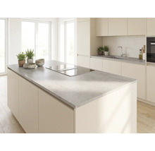 Cuisine moderne et lumineuse avec un grand îlot central, un plan de travail gris aspect béton et une plaque de cuisson avec hotte intégrée.