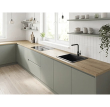 Cuisine moderne avec plan de travail aspect bois, façades mates, évier et robinet noirs près d'une fenêtre.