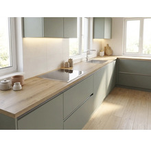 Cuisine d'angle moderne avec des façades vertes, un plan de travail aspect bois, une plaque de cuisson et un évier en acier inoxydable.