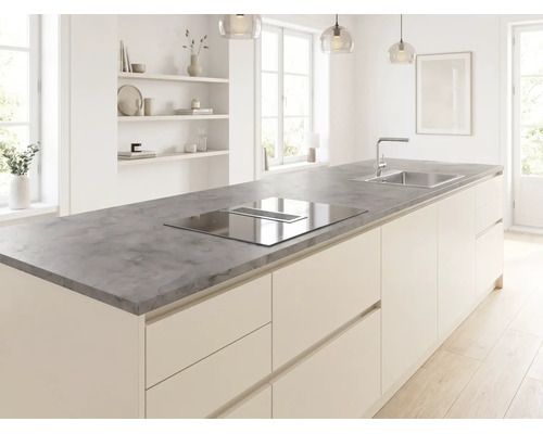 Îlot de cuisine moderne avec plan de travail gris aspect pierre, plaque de cuisson intégrée avec hotte aspirante et évier dans une pièce lumineuse.