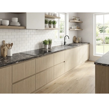 Cuisine moderne lumineuse avec plan de travail aspect marbre sombre, placards en bois clair, carrelage métro blanc et robinetterie noire.