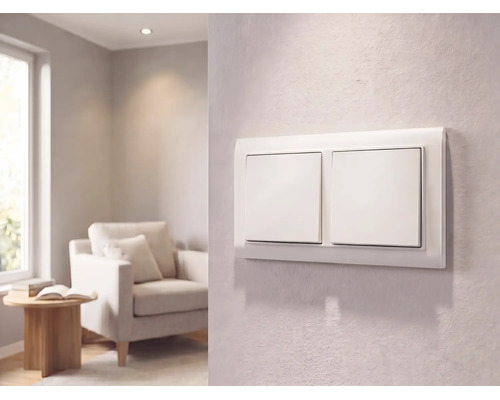 Interrupteur double moderne blanc sur un mur texturé dans un salon lumineux avec fauteuil et petite table.