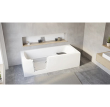 Baignoire sabot blanche moderne avec porte en verre intégrée dans une salle de bain lumineuse avec carrelage gris et étagères en bois.