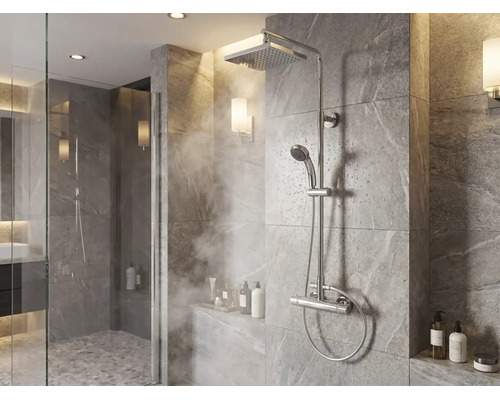 Système de douche moderne avec pomme de douche à effet pluie, douchette à main et mitigeur thermostatique dans une douche carrelée.