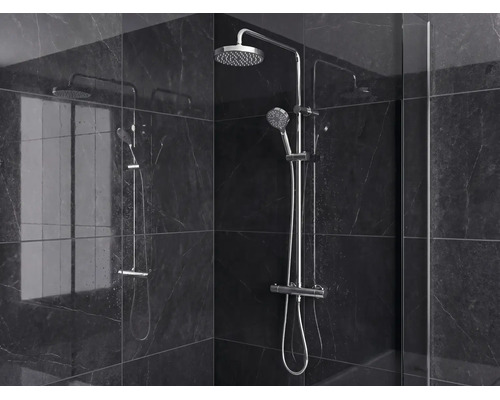 Colonne de douche moderne avec pomme haute, douchette à main et mitigeur thermostatique sur carrelage sombre aspect marbre.