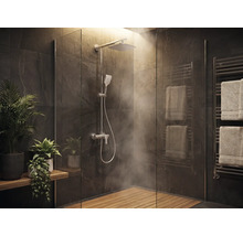 Salle de bains moderne avec douche à l'italienne, douche de tête, caillebotis en bois, carrelage effet pierre, radiateur sèche-serviettes et plantes.